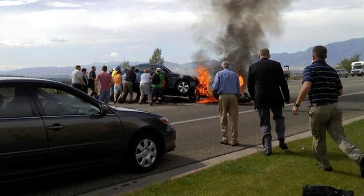 Мотоциклиста вытаскивают из-под горящего BMW