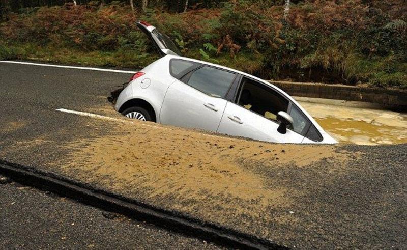 Машина провалилась на дороге и утонула в яме / menmedia.co.uk