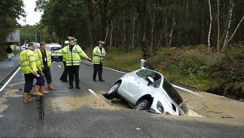 Машина провалилась на дороге и утонула в яме / menmedia.co.uk