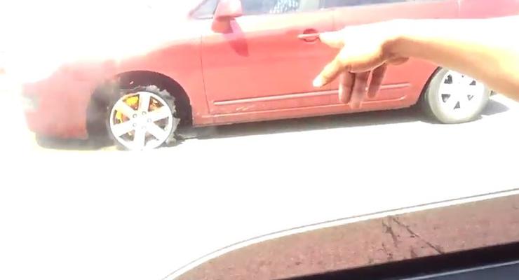 Женщина ездит на Kia c горящей шиной (ВИДЕО)