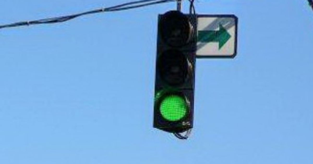 Черная стрелка на зеленом фоне светофора